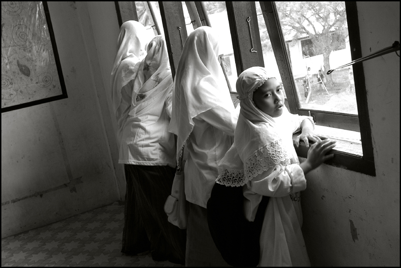 Girls watch the boys outside playing football at an orphanage in Banda Aceh Indonesia