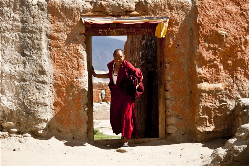 A monk in picture posing as he arrives from the village back to the monastery in Tsarang