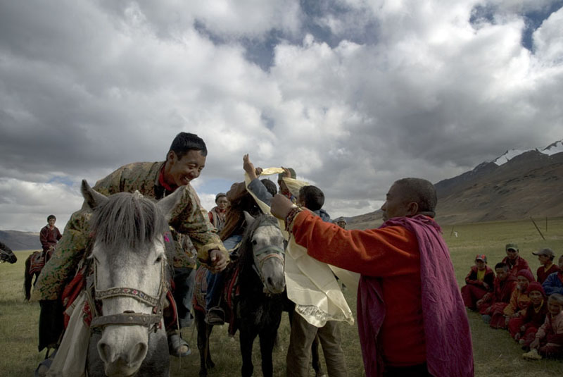 A high monk drapes a kaata, the ceremonial silk scarf,on a Changpa horseman.