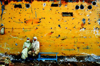 Two workers take a short break while welding inside a ship's hull