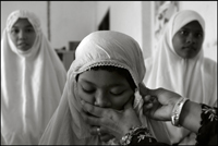 An woman helps a girl to prepare for the midday prayer at an orphanage in Banda Aceh Indonesia