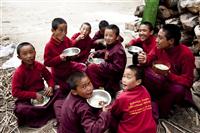 Monks eat together outside the monastery and enjoy their time.