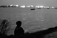 Shafik sits beside river in the evening and thinking about his family
