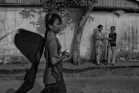 A young girl carries her kite