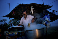 A roadside vendor selling cobs of boiled corn